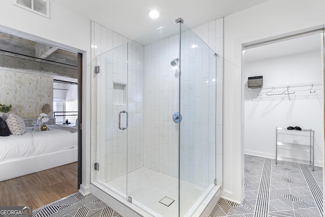 ensuite bathroom with tile patterned flooring, visible vents, baseboards, a stall shower, and ensuite bath