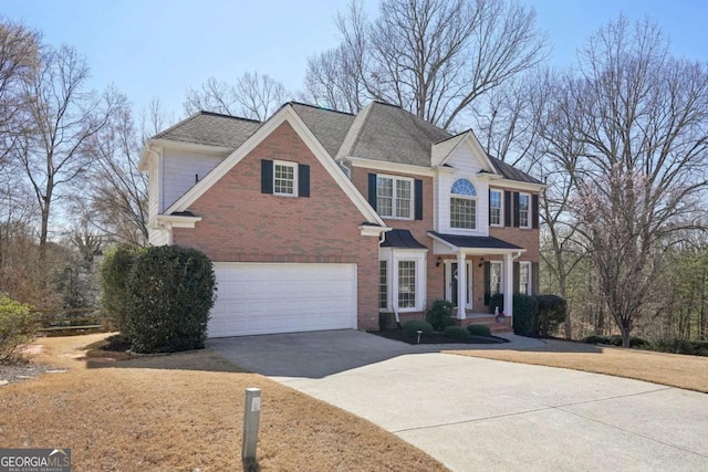 view of front of property with driveway, an attached garage, roof with shingles, and brick siding