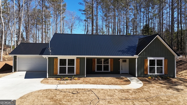 view of front of property with metal roof, a porch, an attached garage, driveway, and board and batten siding