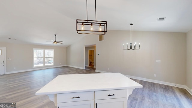 kitchen with light countertops, open floor plan, white cabinets, and light wood finished floors