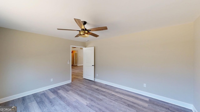 empty room with a ceiling fan, baseboards, and wood finished floors