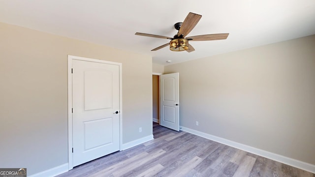unfurnished bedroom featuring ceiling fan, light wood-style floors, and baseboards
