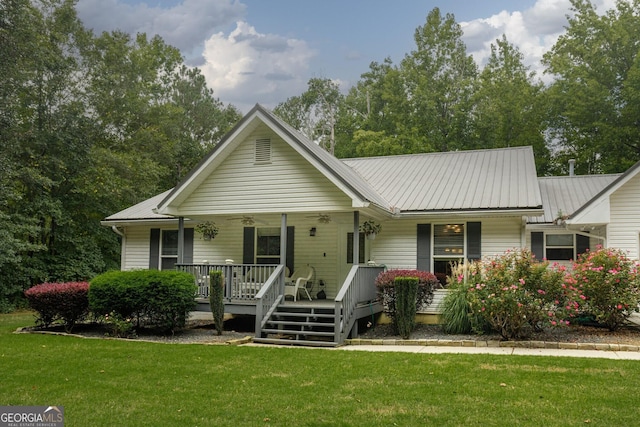 ranch-style home featuring a porch, metal roof, ceiling fan, and a front lawn