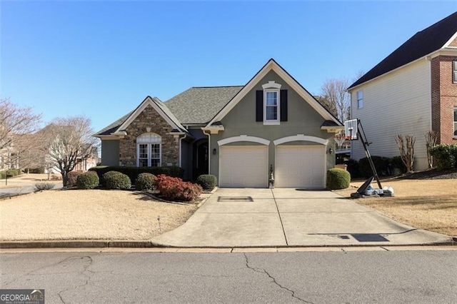 traditional home with a garage, stone siding, concrete driveway, and stucco siding