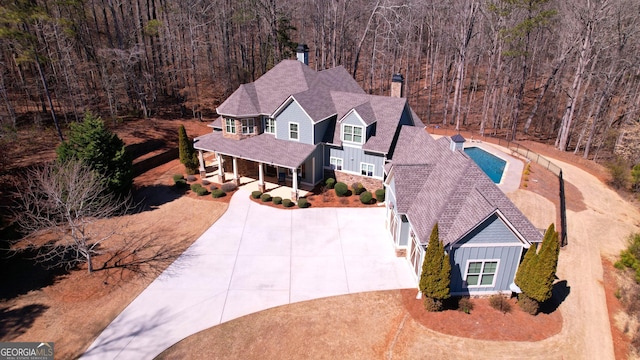 bird's eye view with a wooded view