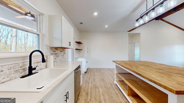 kitchen with open shelves, tasteful backsplash, a sink, and white cabinets