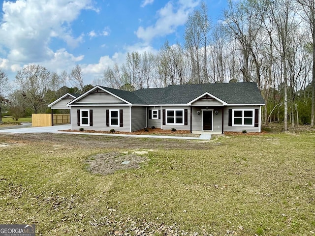 ranch-style house with a front yard and roof with shingles