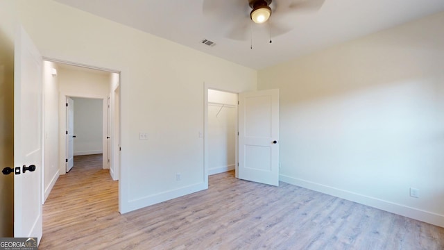 unfurnished bedroom featuring light wood-style flooring, a closet, visible vents, and baseboards