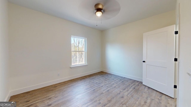 empty room with a ceiling fan, baseboards, and light wood finished floors