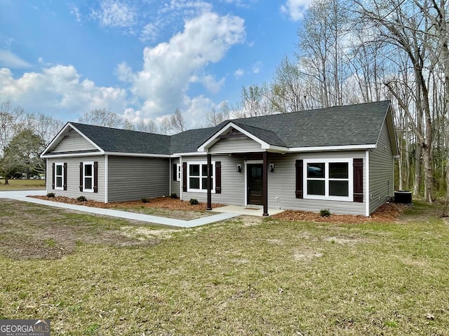 ranch-style home featuring a front lawn and a shingled roof