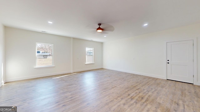 empty room featuring light wood-type flooring, baseboards, a ceiling fan, and recessed lighting