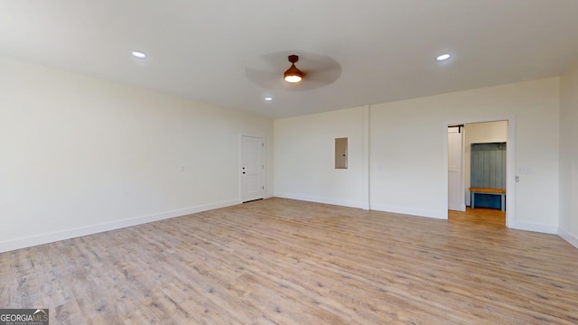 empty room featuring ceiling fan, recessed lighting, baseboards, light wood-style floors, and electric panel