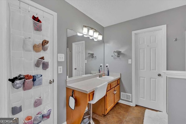 bathroom featuring tile patterned flooring, visible vents, and vanity