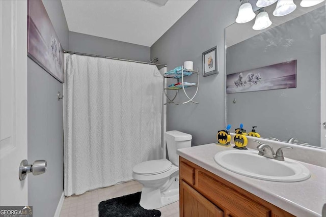 bathroom featuring curtained shower, vanity, toilet, and tile patterned floors