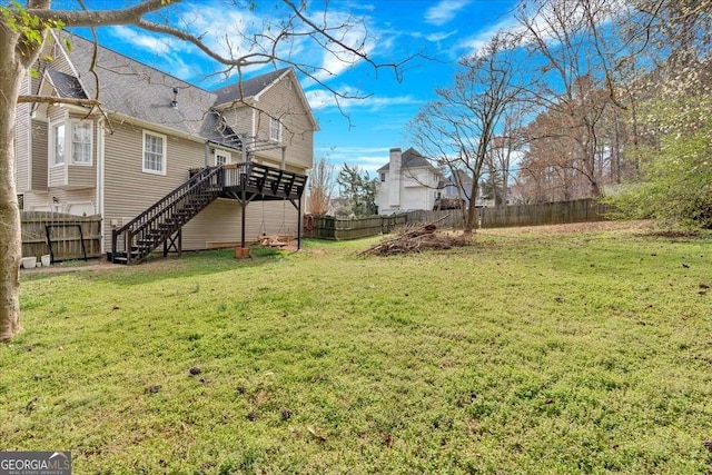 view of yard featuring a fenced backyard and stairs