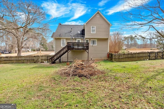 rear view of property with fence private yard, a wooden deck, stairs, and a yard