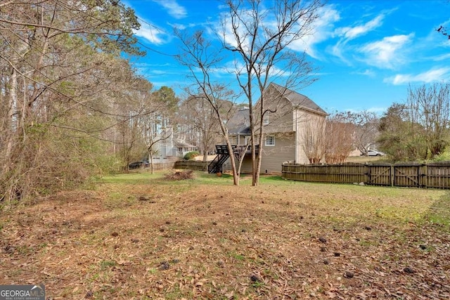 view of yard featuring stairs and fence