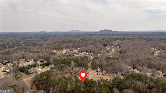 drone / aerial view with a wooded view and a mountain view