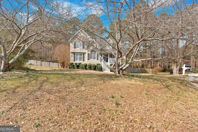 view of front of house with a front yard and fence