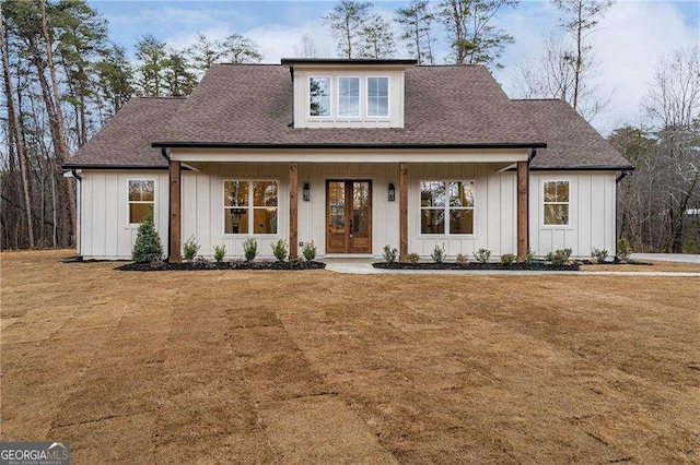 modern farmhouse style home with board and batten siding, roof with shingles, and a front lawn