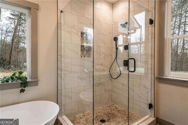 bathroom featuring a stall shower and a freestanding tub