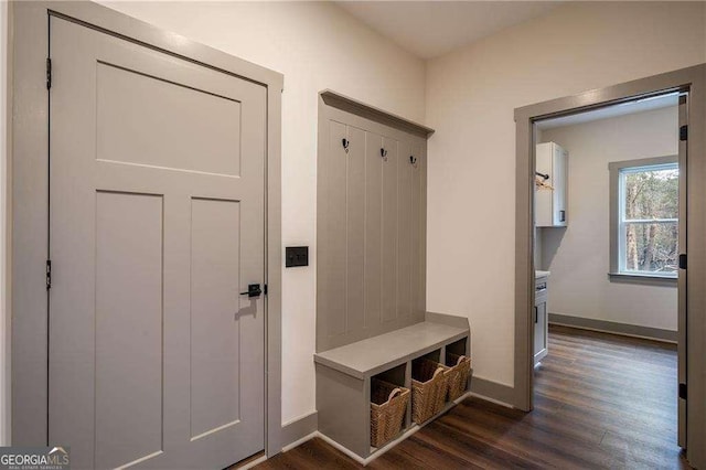 mudroom with dark wood-style flooring and baseboards