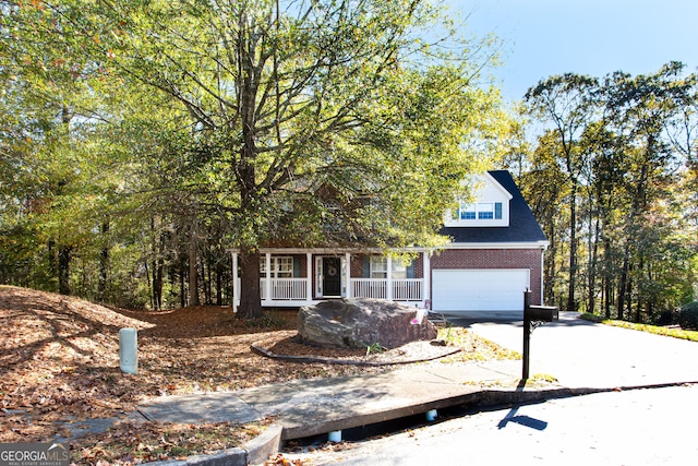 obstructed view of property featuring an attached garage, brick siding, covered porch, and driveway