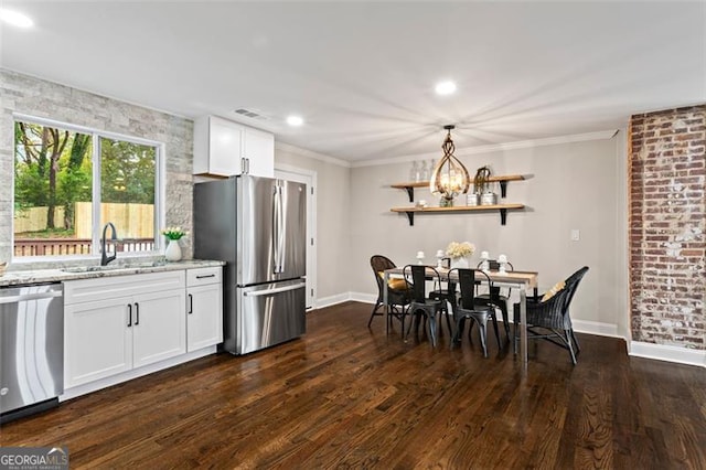 kitchen featuring light stone counters, dark wood-type flooring, white cabinets, ornamental molding, and appliances with stainless steel finishes