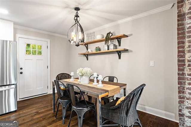 dining room with dark wood-style floors, ornamental molding, a notable chandelier, and baseboards