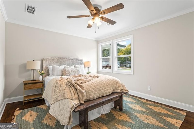 bedroom featuring ornamental molding, visible vents, baseboards, and wood finished floors