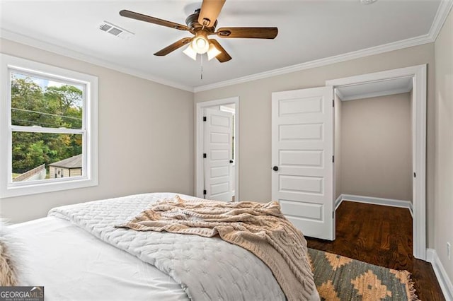 bedroom with baseboards, visible vents, wood finished floors, and ornamental molding