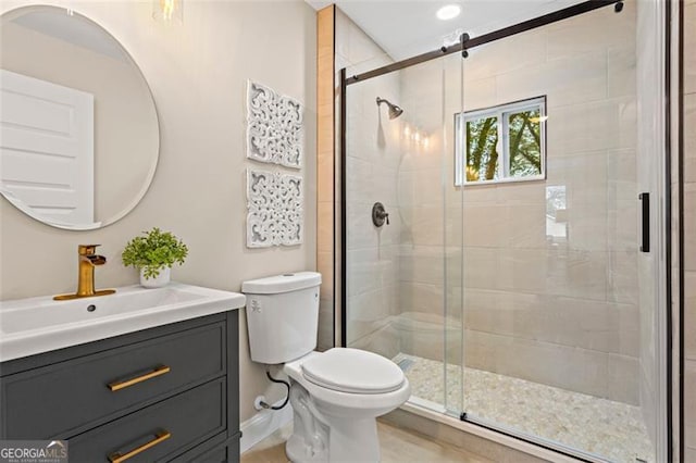 full bath featuring toilet, a shower stall, and vanity