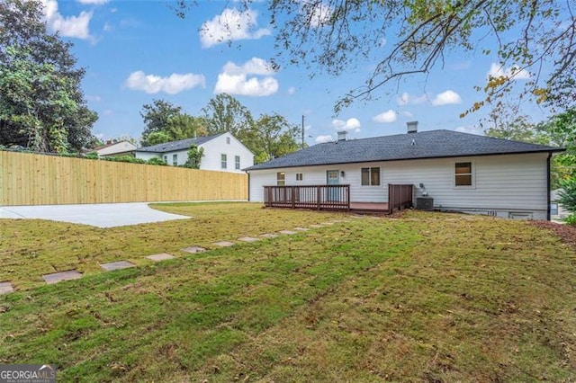 back of property featuring a yard, fence, and a wooden deck