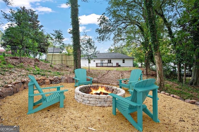 exterior space featuring an outdoor fire pit and fence