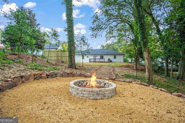 view of yard with an outdoor fire pit and fence