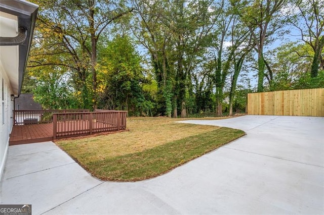 view of yard featuring fence and a deck