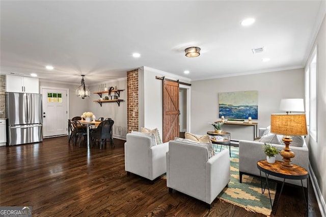 living area with a barn door, visible vents, ornamental molding, and dark wood-type flooring