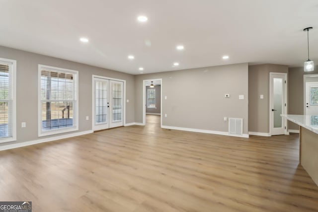 unfurnished living room with visible vents, recessed lighting, light wood-type flooring, and baseboards