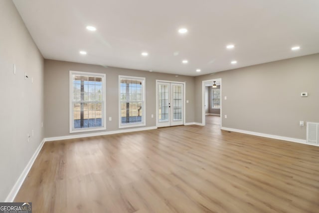 unfurnished living room with light wood finished floors, visible vents, recessed lighting, and baseboards