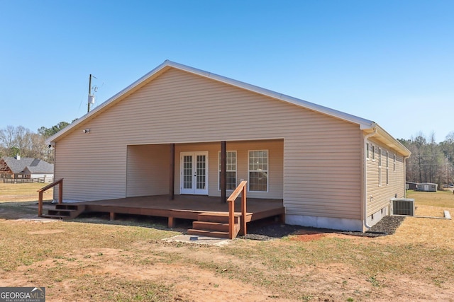 rear view of property with central AC unit, french doors, and a yard