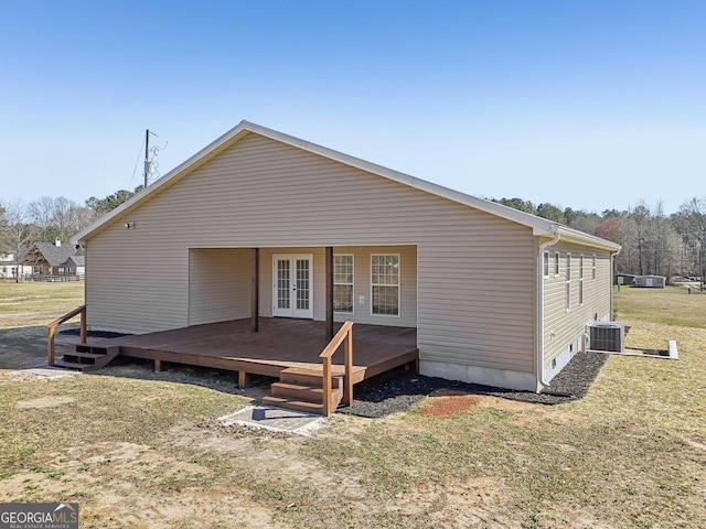 rear view of property featuring central AC unit, french doors, and a yard