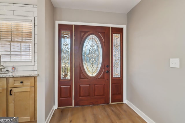 entryway featuring baseboards and wood finished floors