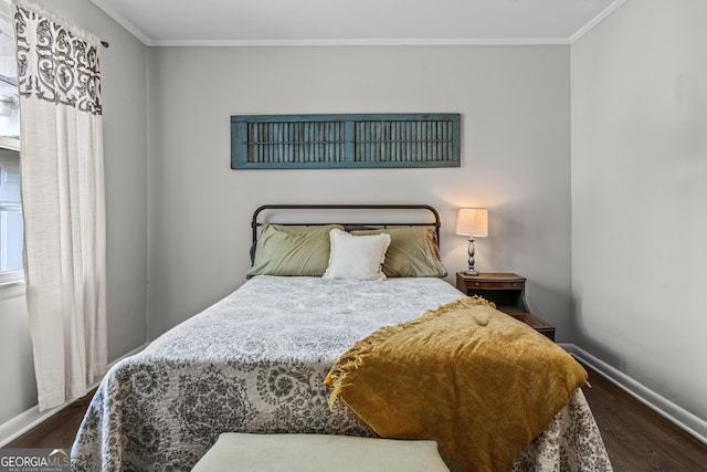 bedroom featuring baseboards, ornamental molding, and wood finished floors