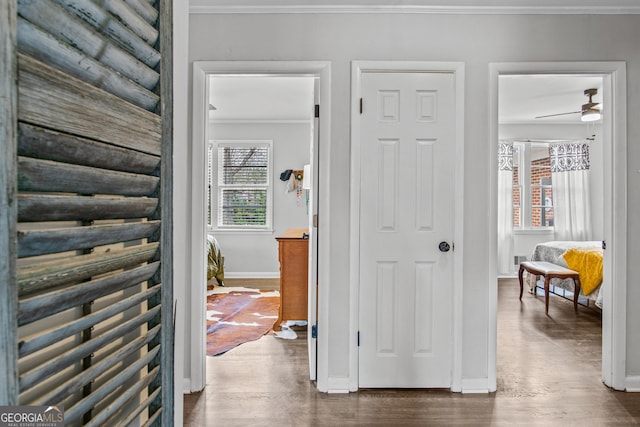 hall with ornamental molding, dark wood finished floors, and baseboards