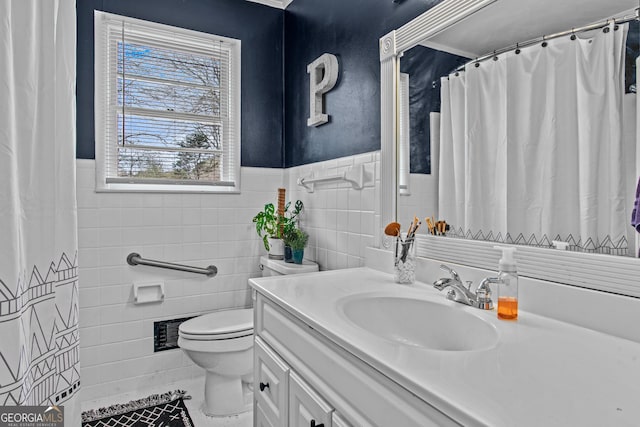 full bath with visible vents, toilet, a wainscoted wall, vanity, and tile walls