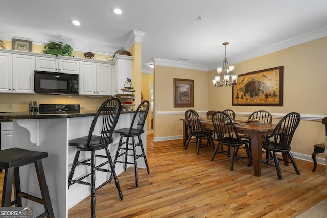 dining room featuring light wood finished floors, baseboards, an inviting chandelier, crown molding, and recessed lighting