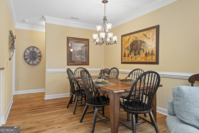 dining room with light wood-style floors, visible vents, ornamental molding, and baseboards