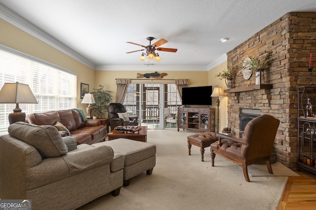 living room with a healthy amount of sunlight, a fireplace, ornamental molding, and a textured ceiling