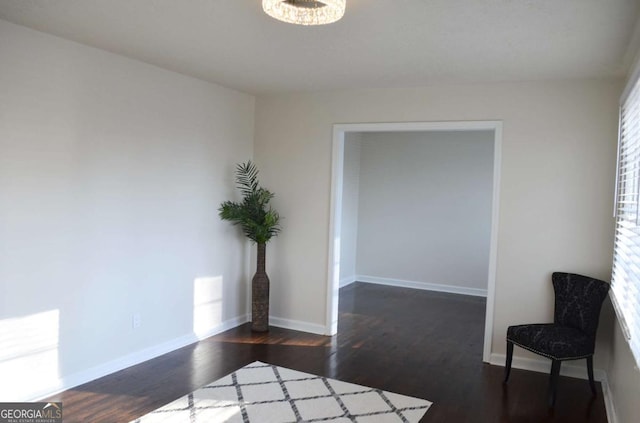 spare room featuring baseboards and dark wood-type flooring