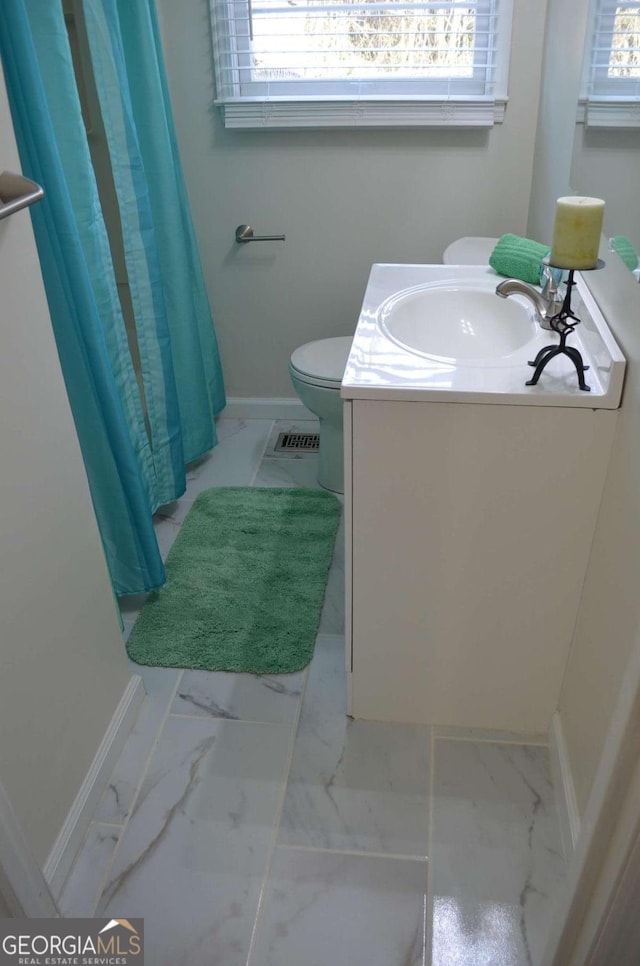 bathroom with marble finish floor, visible vents, vanity, and baseboards